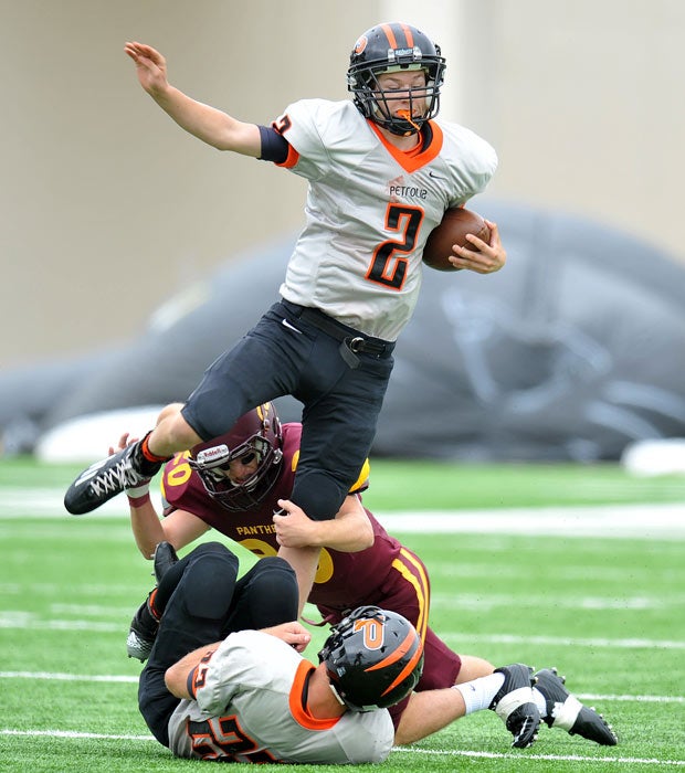 Petrolia (Texas) quarterback Johnathan Baker attempts to elude a Bells defender.