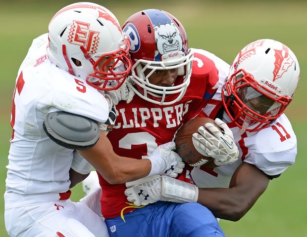 Bellport (N.Y.) running back Jabari M'bhaso is sandwiched by East Islip defenders Justin Taveras (left) and Hugens Tranquille.