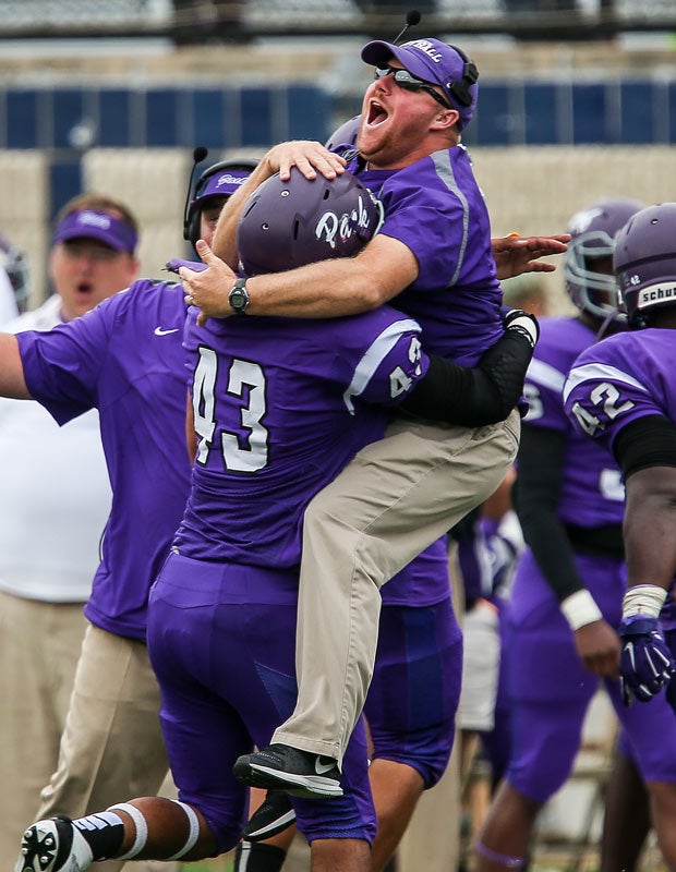A Lufkin (Texas) coach leaps to give player Jacob Mark a bear hug during a game against Curtis.