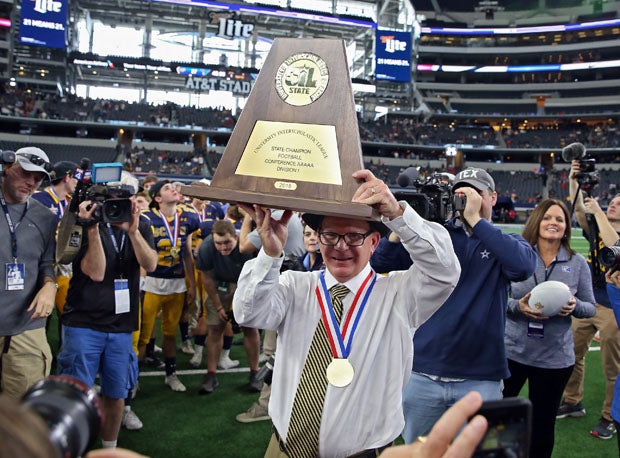 Highland Park coach Randy Allen holds up the program's sixth state championship trophy.