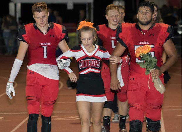 Adamietz is escorted by football players Carson Marx (left) and Ryan Caetano.