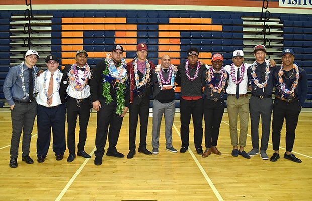 The Bishop Gorman football team and coach Kenny Sanchez pose following a ceremony at school.