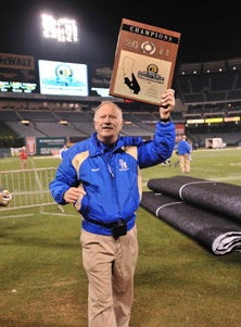 Harry Welch holds up ninth Southern
Section title he's won.
