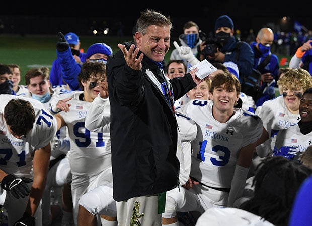 Head coach Steve Specht smiles broadly while addressing his players.