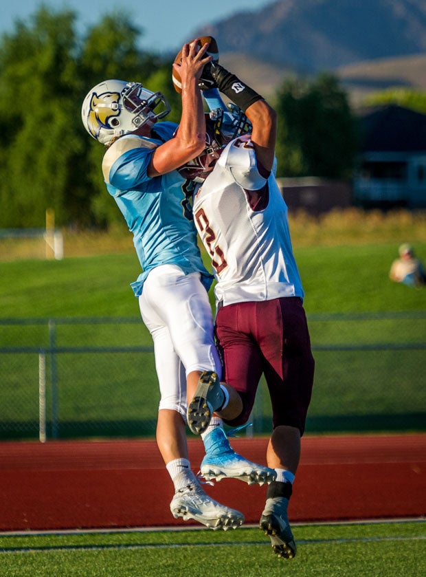 Logan Miller from Sky View (Smithfield, Utah) leaps over Jake Mafi of Maple Mountain (Spanish Fork, Utah).