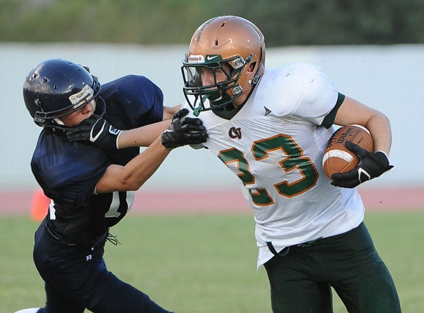 A Campo Verde (Gilbert, Ariz.) ballcarrier fights away a tackler from Perry (Gilbert, Ariz.) in a freshman game.