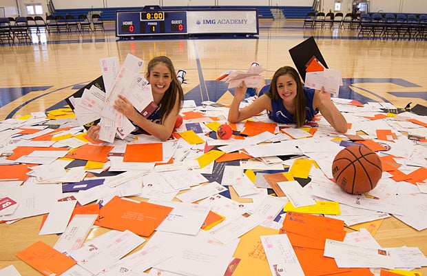 Audrey-Ann and Khaleann Caron-Goudreau surrounded by hundreds of letters poured in from colleges across the nation looking to sign the talented twins.