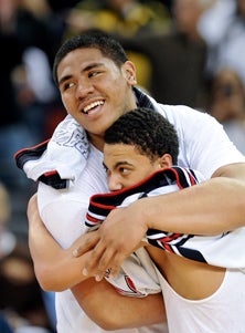 Freshman Freddie Tagaloa (left) 
gives a bear hug to a suffocating
teammate. 