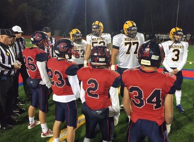 At the coin toss, Campolindo coach Kevin Macy made sure his Cougars (in red) were looking up at Milpitas. 