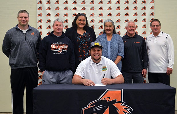 Aledo (Texas) offensive lineman Chuck Filiaga proudly signs with Michigan.