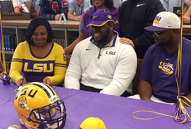 Norte Dame (La.) Tyler Shelvin signs with LSU while surrounded by his family.