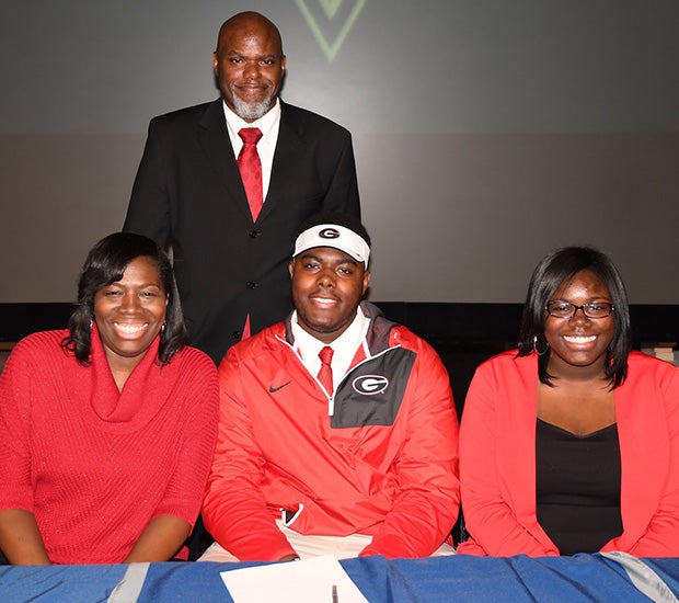 Parents Belinda and Andre Thomas and sister Brianna help Pace Academy (Ga.) offensive lineman Andrew Thomas celebrate his commitment to the University of Georgia.