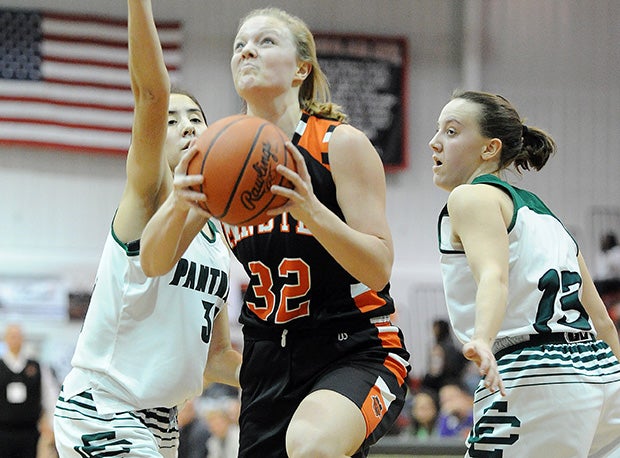 Minster's Demaris Wolf glides through a pair of Elyria Catholic defenders looking to score at the Classic in the Country Challenge earlier this year.
