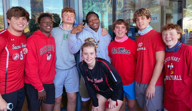 Newman football players pose with state champion May Manning. 