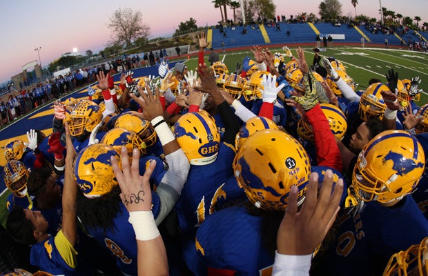 Grant players raise five fingers in a pregame tribute to Jaulon Clavo, who wore jersey number 5.