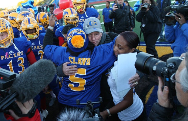 Grant head coach Mike Alberghini embraces Nicole Clavo at midfield before the start of Monday's playoff game.
