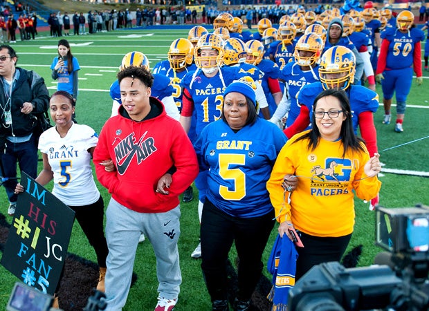 Nicole Clavo (second from the right), the mother of Jaulon, leads the Grant players onto the field before kickoff. Grant senior Malik Johnson (third from the right) joins her as he was shot in the arm in the shooting that claimed Nicole's son.