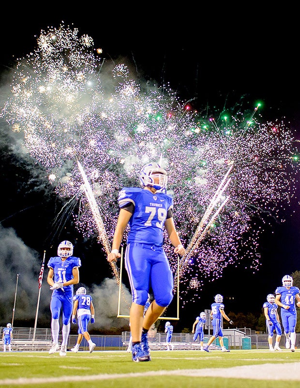 Rocklin (Calif.) players finish their halftime warm-ups as homecoming fireworks explode in the sky against visiting Oak Ridge.