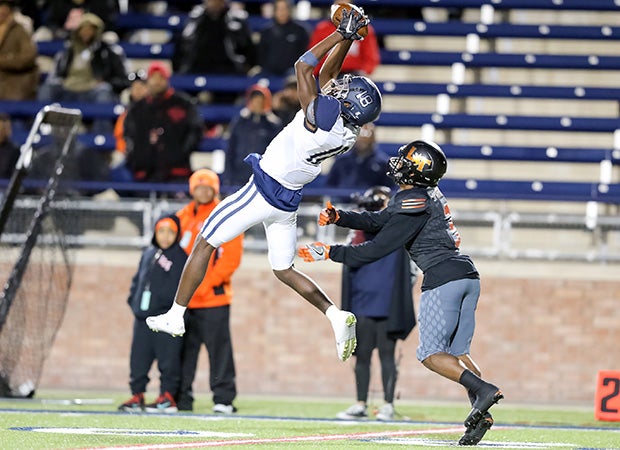 Wylie East (Texas) player Ronald Smith leaps to make a catch in front of Lancaster cornerback Jaymir Sparrow in a UIL state playoff game.