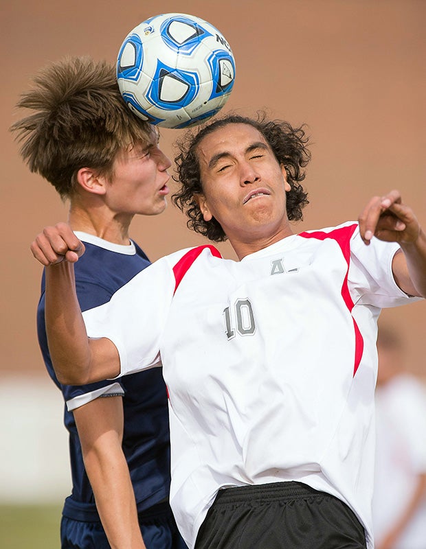 Aurora West College Prep (Colo.) middlefielder Jaime Gutierrez (right) collides with a player from The Academy.