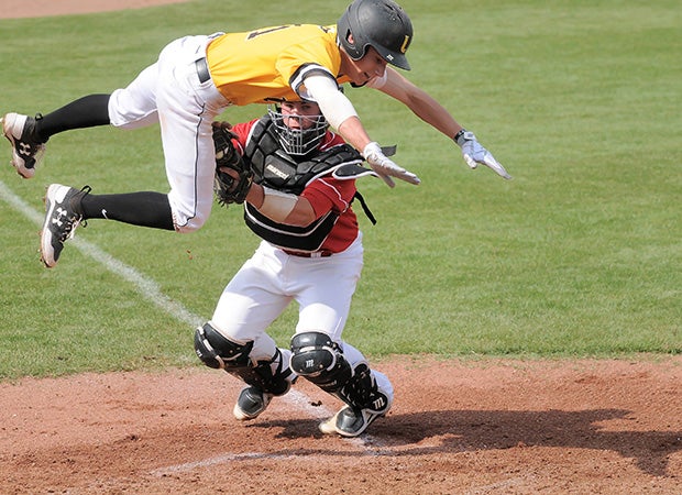 William Safford of University Lab (Baton Rouge, La.) leaps over an Assumption catcher in an attempt to avoid being tagged out at the plate during a game in the ACHS Tournament in Louisiana.