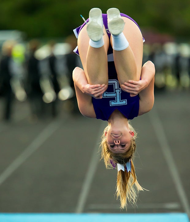 A cheerleader from Timber Creek (Orlando, Fla.) flips for her team during a game against East River.