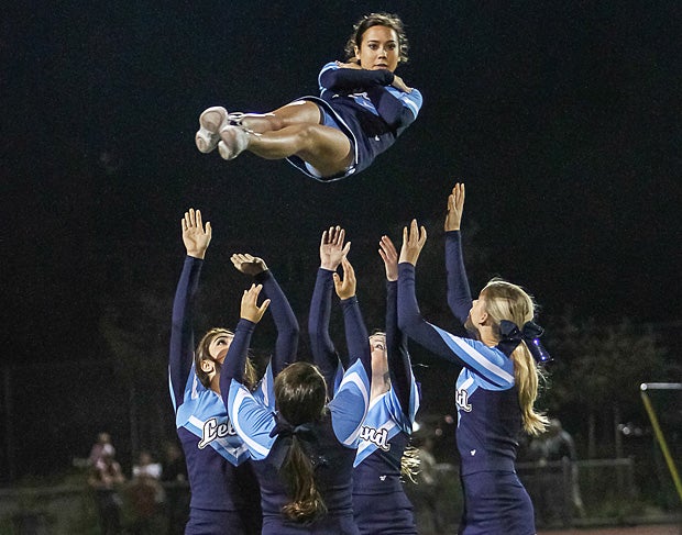 Leland (San Jose, Calif.) cheerleaders throw their teammate into the night sky.