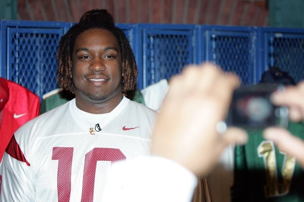 Seantrel Henderson poses for a picture by his father at CBS College Sports studios.