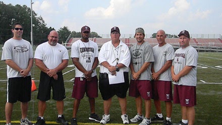 John Vogan (middle) and his old-school approach has helped Conestoga reach baseball supremacy in Pennsylvania. He makes sure to share the success, like for example how he doesn't like having his picture taken without his staff surrounding him.