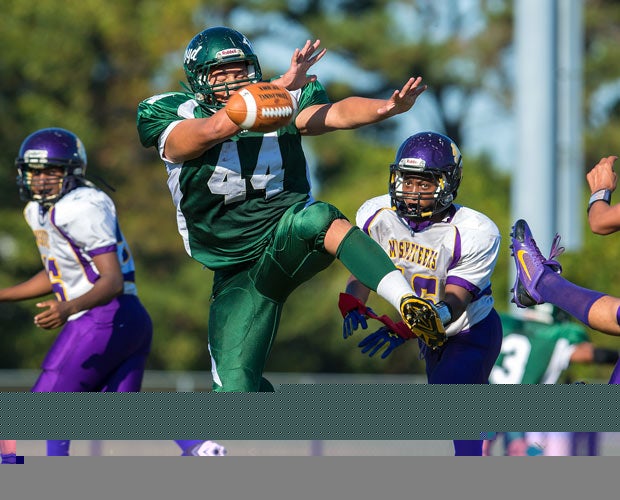 A William Floyd (N.Y.) player leaps while attempting to block a punt against Central Islip.
