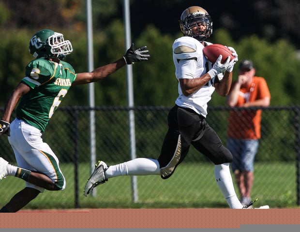 Greece Athena (N.Y.) receiver Osondi Dimbga catches a touchdown pass in front of a Greece Olympia defender.