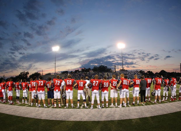 Boyd (Texas) players stand along the sideline during the national anthem at their recent home game against Plano West.
