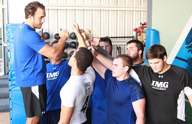 Working with strength and conditioning coach Matt Smith (far left), Foster motivates his fellow seniors preparing for the transition to college.