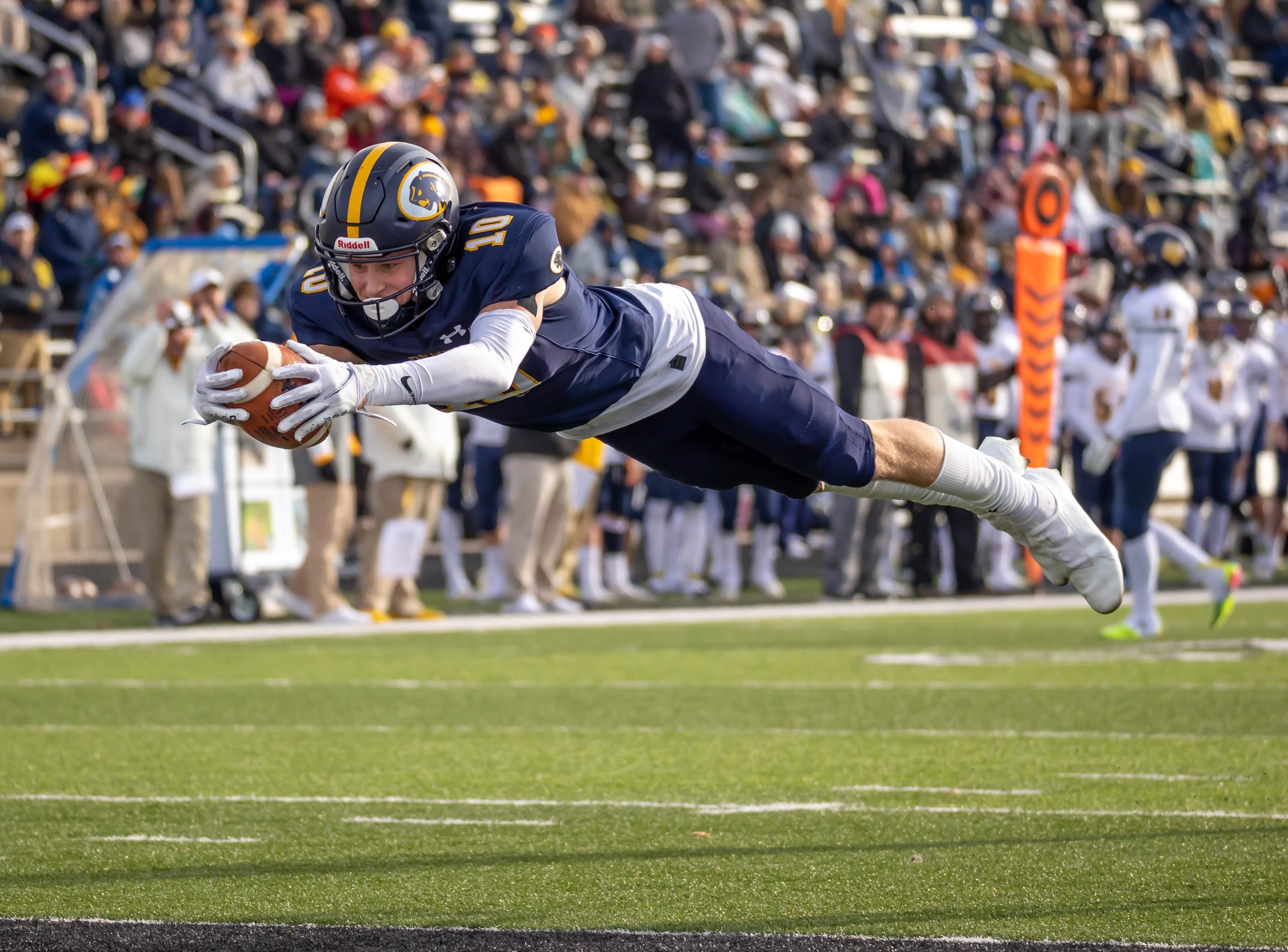 Player diving for the end zone after catching a pass.