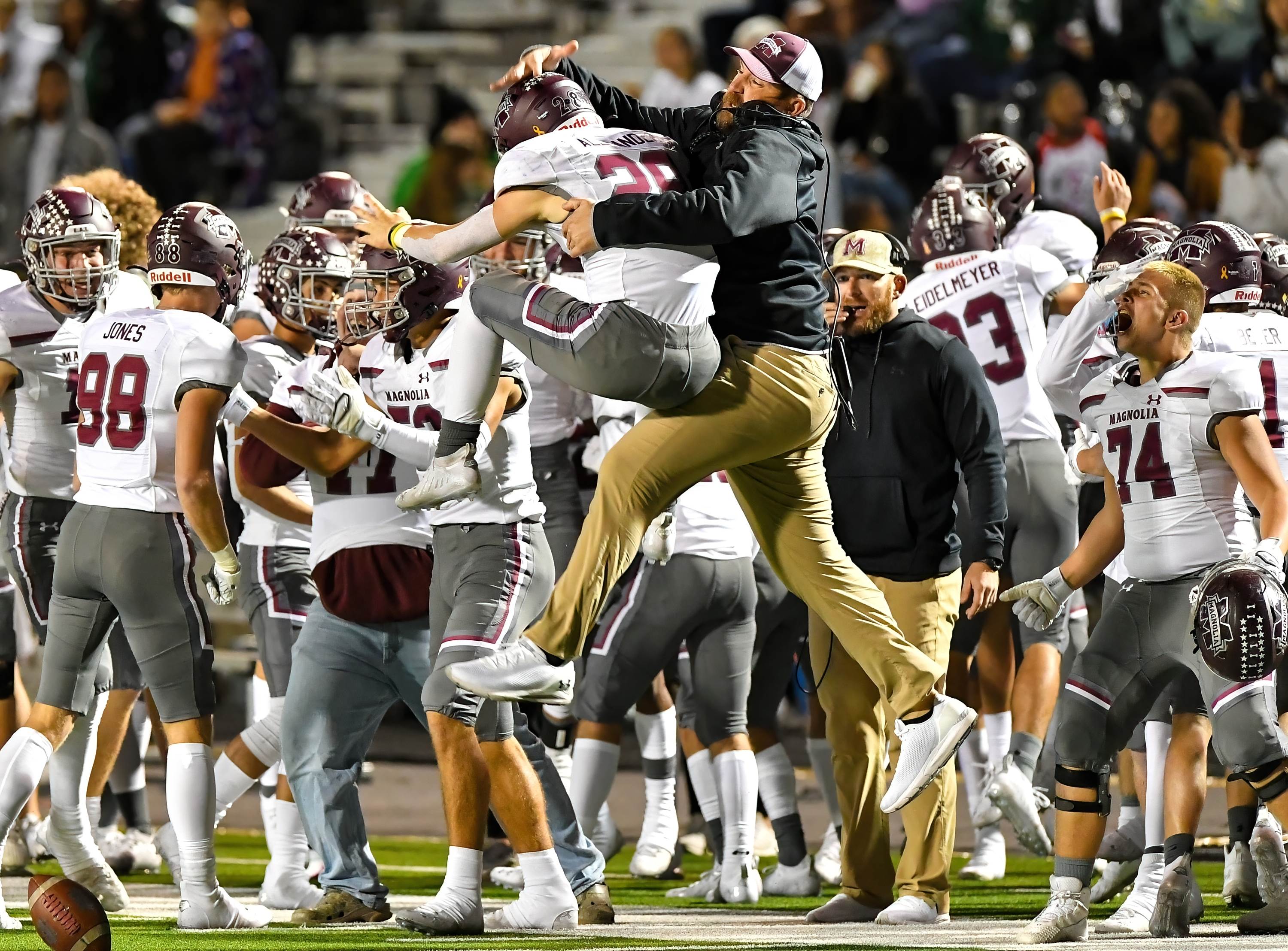 John Alexander from Magnolia TX gets congratulated by his coach in bi-district playoff action against Longview TX