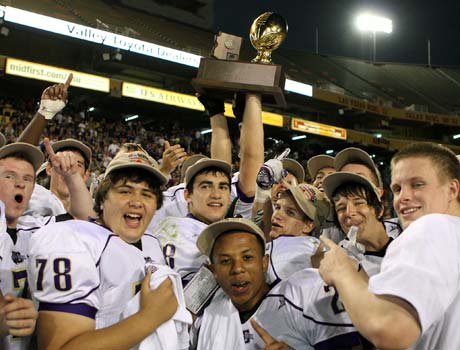 Queen Creek players hoist the championship trophy following their victory in the Division 3 title game on Saturday.