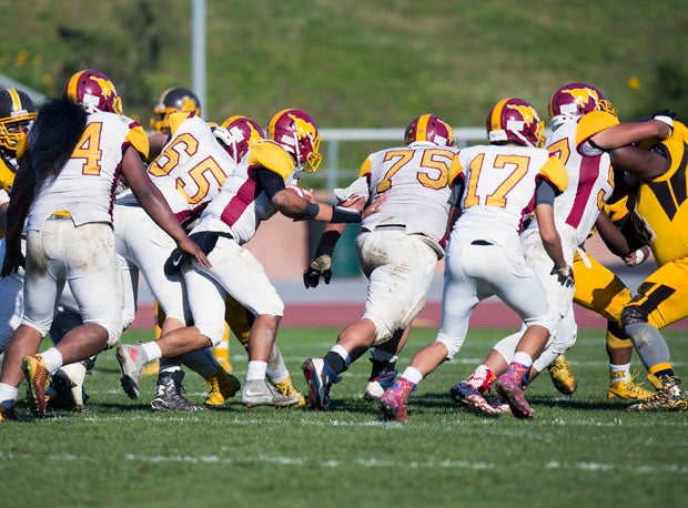 Ronald Phelps (75) leads an onslaught of offensive linemen.