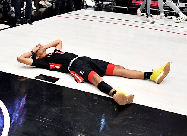 Jaylen Clark lays dejected on the court following the stunning defeat.