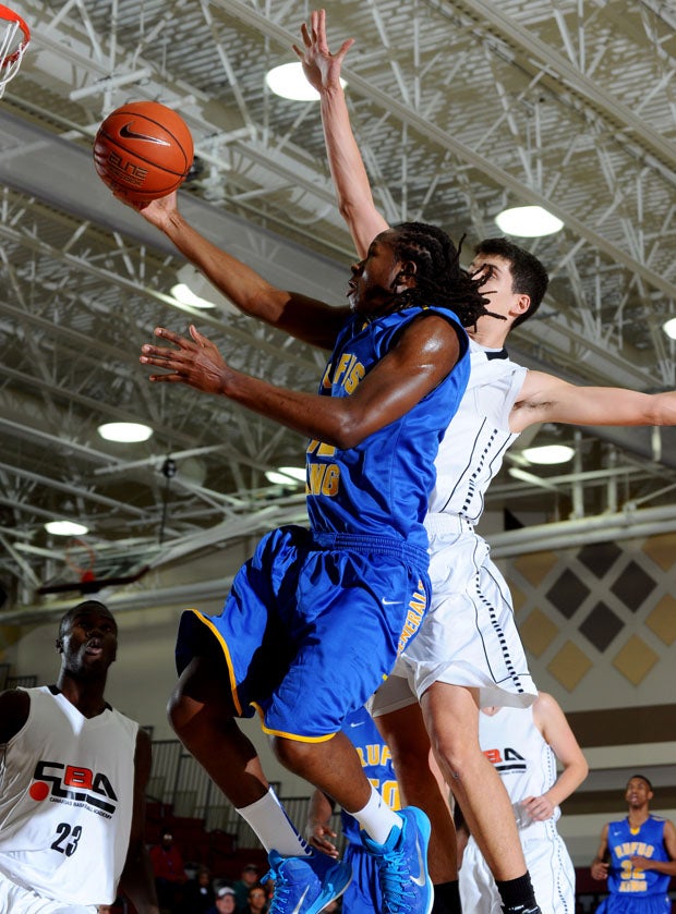 King's Joe Binyoti flies in for a lay-up under heavy duress.