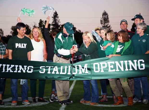 Palo Alto coach Earl Hansen cuts the ribbon, commemorating the opening of school's renovated stadium Friday. See San Francisco 49ers' coach Jim Harbaugh in the background.