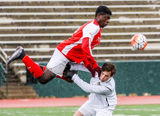 A Judge Memorial (Salt Lake City, Utah) player (top) collies with a Hillcrest player while battling for the ball.