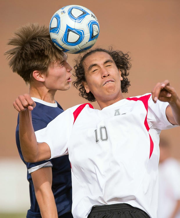 Aurora West College Prep (Colo.) middlefielder Jaime Gutierrez (right) collides with a The Academy player for a header.