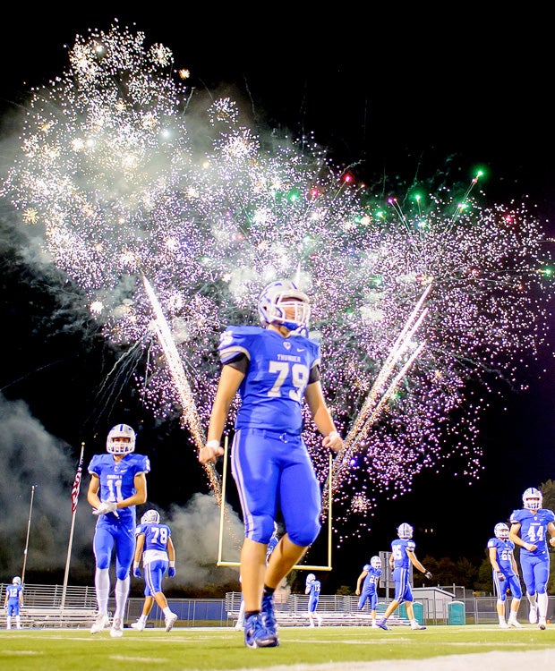 Rocklin (Calif.) players finish their halftime warm-ups as homecoming fireworks explode in the sky against visiting Oak Ridge.