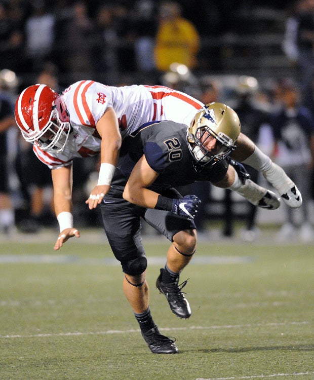 Mater Dei (Calif.) linebacker Steele Dubar soars over St. John Bosco's Eli DeRoon during a punt.