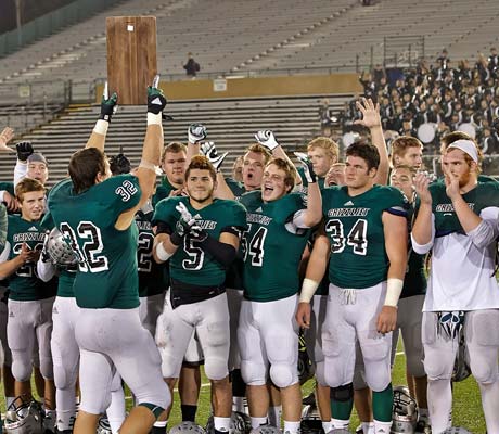 Granite Bay's Taft Partridge proudly displays the regional championship plaque to his cheering teammates and the Grizzlies' fans in the stands.
