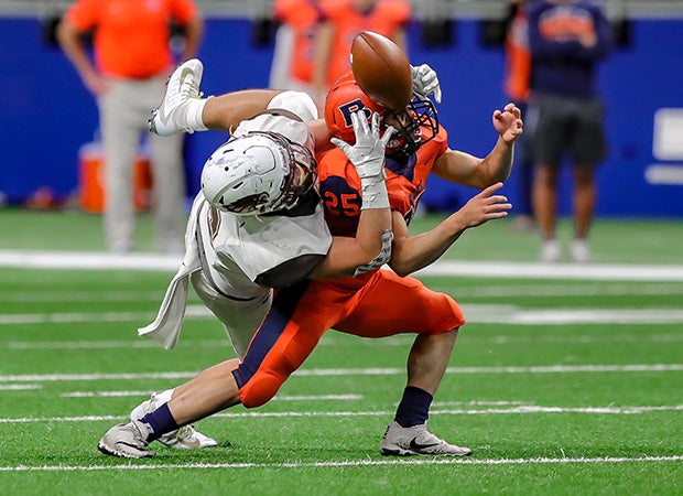 Hanna (Texas) receiver Aaron Frausto reaches over to break up a possible interception by Kaine Buchanan of Brandeis in a UIL 6A Division 2 quarterfinal game at the Alamodome in San Antonio.