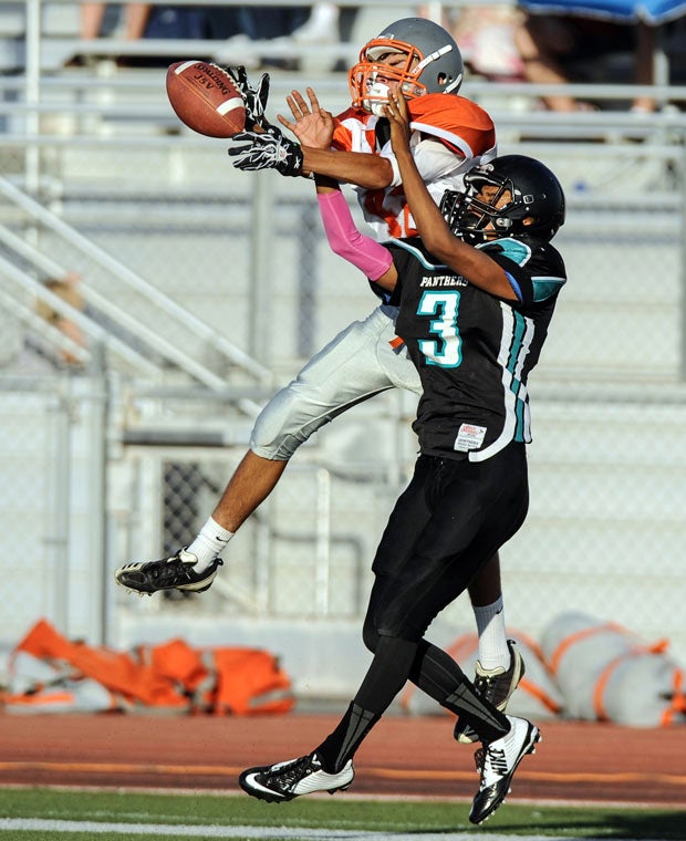 An Atascadero (Calif.) player and a Pioneer Valley player battle for possession of a pass during a junior varsity game.