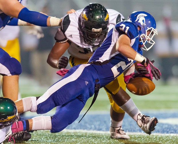 Hempfield Area (Pa.) running back Lorenzo Barchetti fumbles while being tackled by a Penn-Trafford defender.