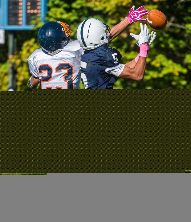 A Milton Academy (Mass.) defender reaches while tipping a pass away from a Lawrence Academy receiver. 