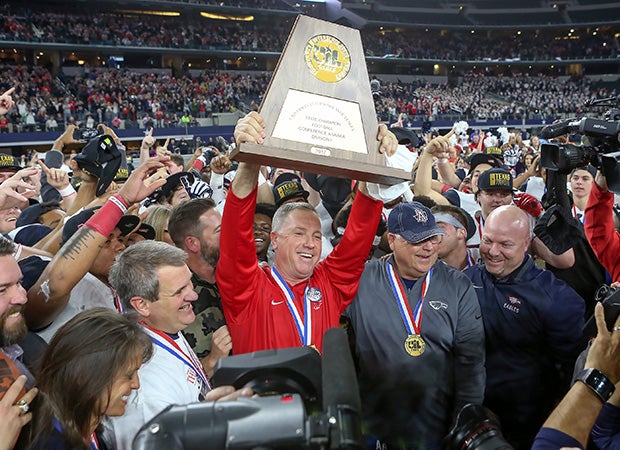 Head coach Terry Gambill proudly hoists the trophy following his team's victory in the UIL 6A Division 1 championship game at the end of last season.